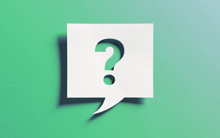 Notizzettel mit Schatten als Sprechblase mit einem Fragezeichen ausgeschnitten vor grün/türkisen Hintergrund